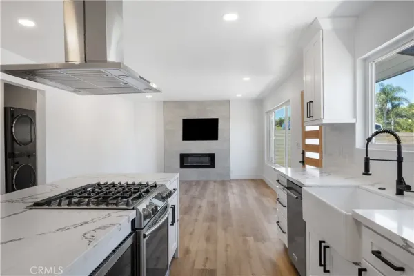 a kitchen with granite countertop a sink stove and cabinets