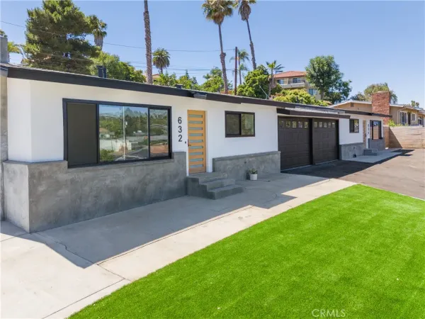 a front view of a house with a garden and yard
