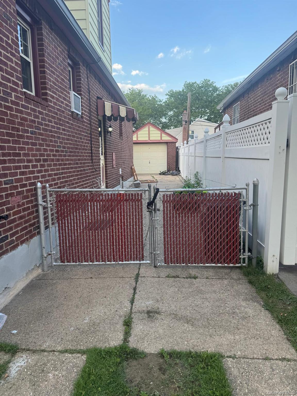 80-23 247th Street Queens, NY 11426 - Photo 11 of 19 a view of a brick house with wooden fence and trees