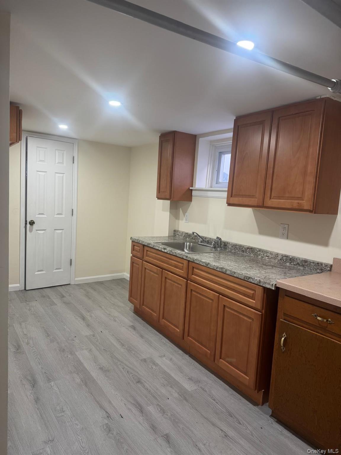 80-23 247th Street Queens, NY 11426 - Photo 13 of 19 a kitchen with granite countertop sink cabinets and stainless steel appliances