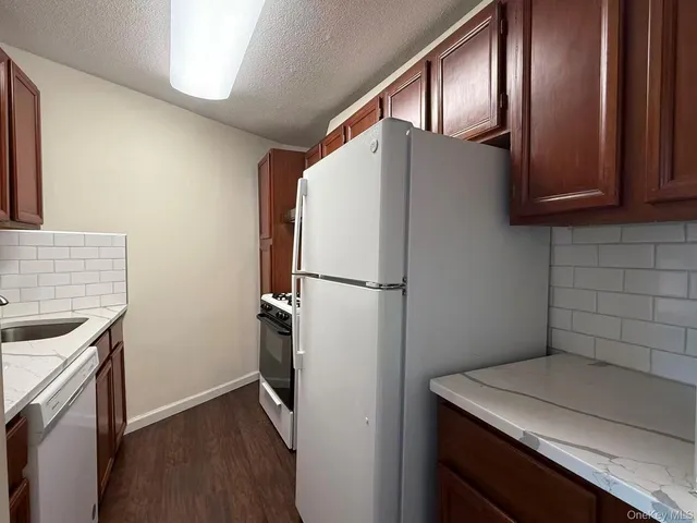 a kitchen with a refrigerator sink and cabinets