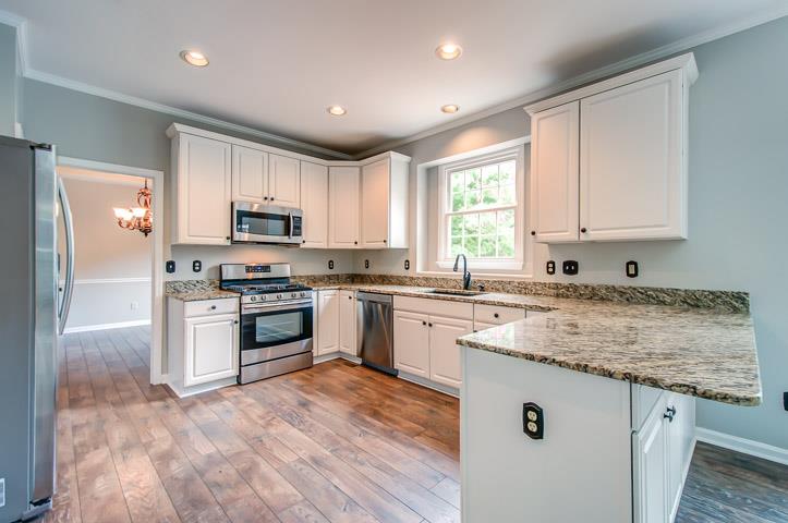 109 Chester Stevens Road Franklin, TN 37067 - Photo 11 of 30 a kitchen with kitchen island granite countertop white cabinets and white appliances