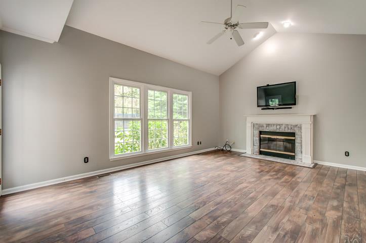 109 Chester Stevens Road Franklin, TN 37067 - Photo 9 of 30 an empty room with windows fireplace and a flat screen tv