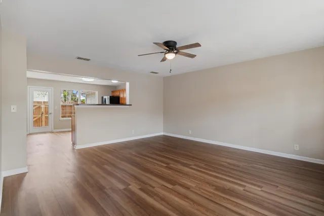 a view of a kitchen with wooden floor and a ceiling fan