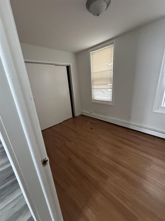 596 Adams Avenue, Unit 1 Elizabeth, NJ 07201 - Photo 8 of 11 a view of an empty room with wooden floor and a window