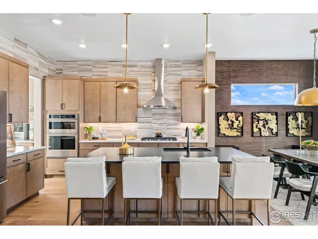 a dining hall with stainless steel appliances kitchen island granite countertop a dining table chairs and view living room