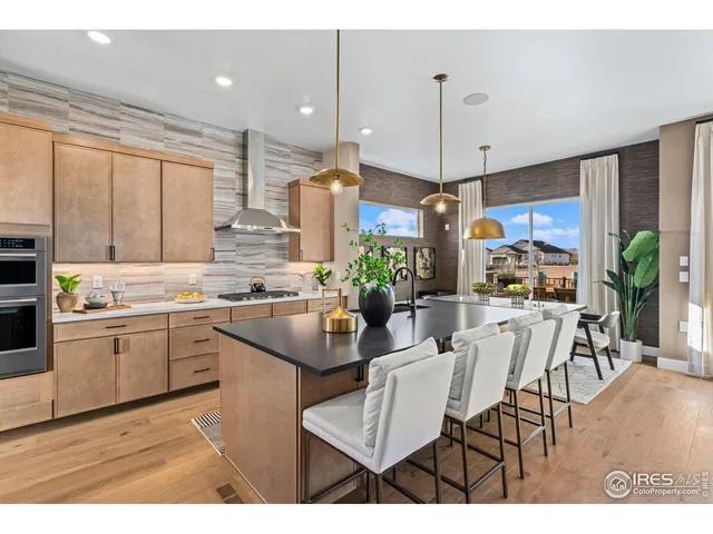 a kitchen with kitchen island granite countertop a sink cabinets and wooden floor