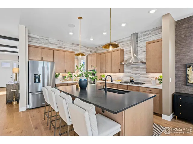 a kitchen with kitchen island granite countertop a sink counter top space appliances and cabinets