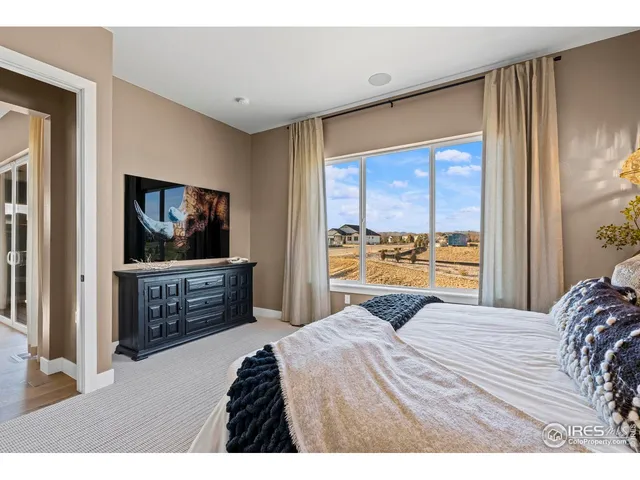 a spacious bedroom with a bed and a painting on the wall