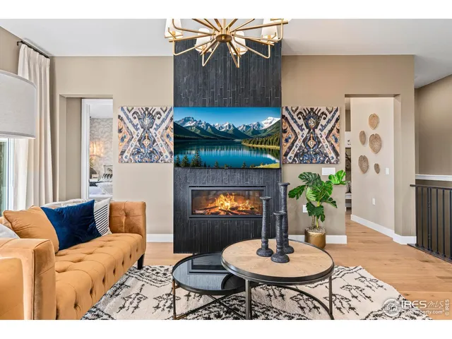 a living room with furniture a fireplace and a chandelier