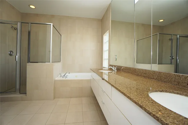 a bathroom with a granite countertop double vanity sink and mirror