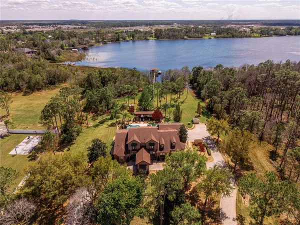 an aerial view of residential houses with outdoor space and lake view