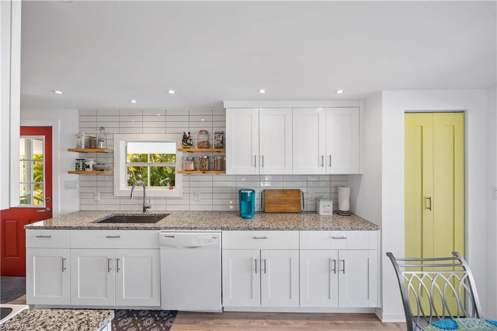 216 Rookery Road Naples, FL 34114 - Photo 11 of 44 a kitchen with granite countertop a sink white cabinets and a granite counter tops
