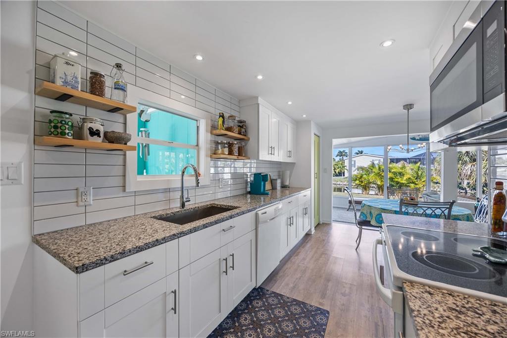 216 Rookery Road Naples, FL 34114 - Photo 12 of 44 a kitchen with stainless steel appliances granite countertop a sink stove and cabinets