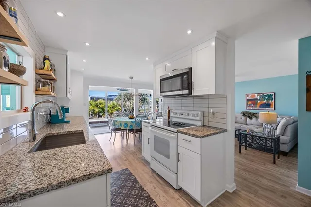 a kitchen with stainless steel appliances granite countertop a stove a sink and a microwave