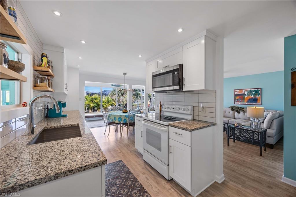 216 Rookery Road Naples, FL 34114 - Photo 13 of 44 a kitchen with stainless steel appliances granite countertop a stove a sink and a microwave
