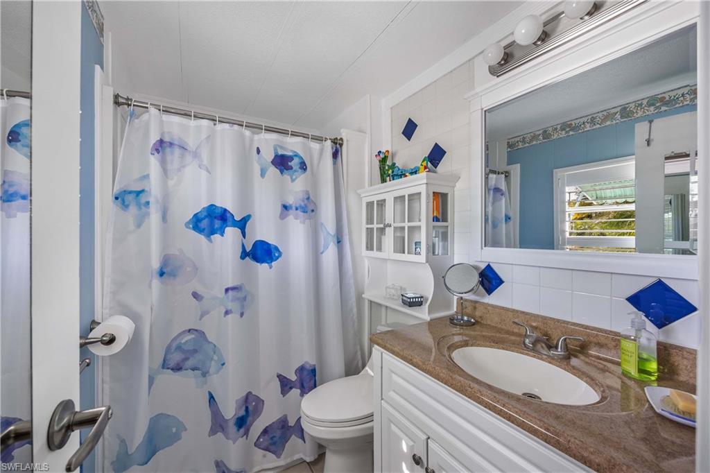216 Rookery Road Naples, FL 34114 - Photo 20 of 44 a bath room with a sink a toilet and a mirror