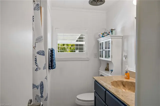a bathroom with a granite countertop sink toilet and mirror