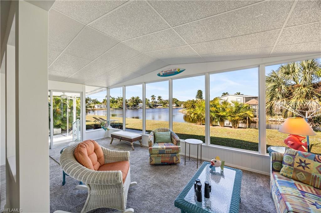 216 Rookery Road Naples, FL 34114 - Photo 23 of 44 a living room with patio furniture and a floor to ceiling window