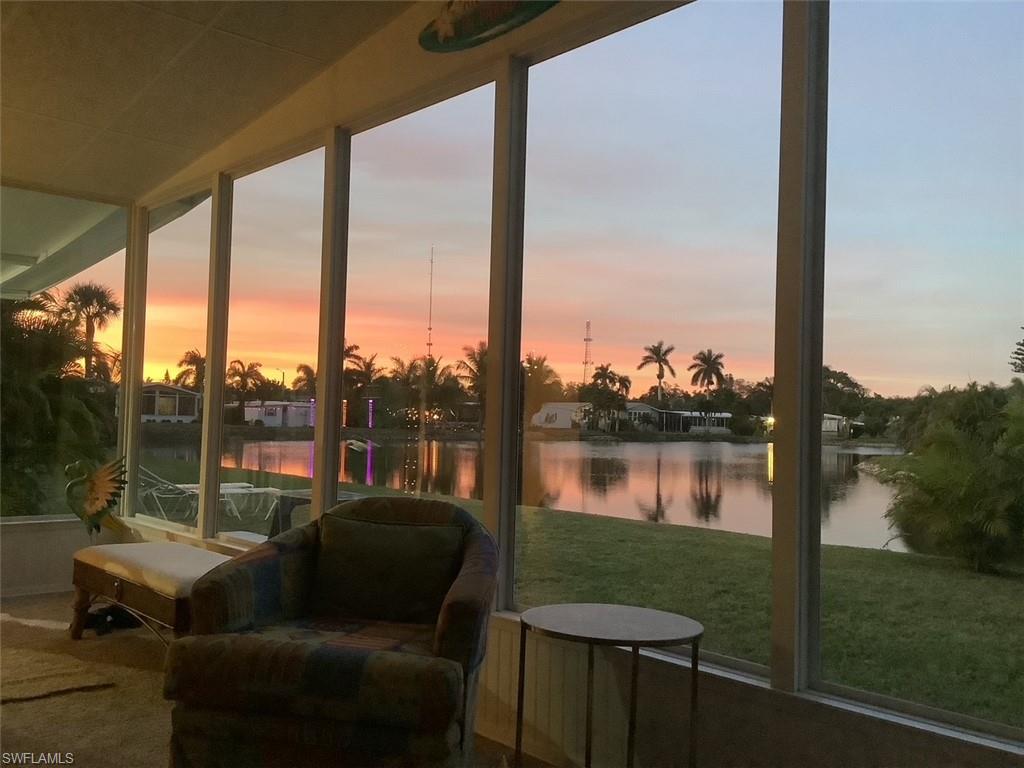 216 Rookery Road Naples, FL 34114 - Photo 43 of 44 a view of a lake from a balcony with floor to ceiling windows with yard