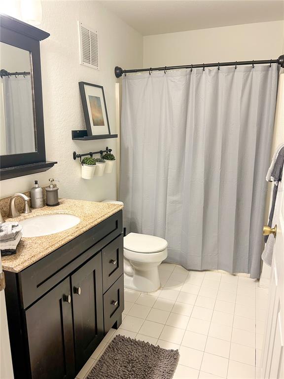 5447 Vineland Road, Unit 1209 Orlando, FL 32811 - Photo 17 of 27 a bathroom with a granite countertop sink toilet and shower