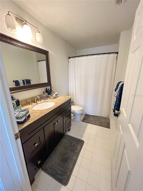 5447 Vineland Road, Unit 1209 Orlando, FL 32811 - Photo 21 of 27 a bathroom with a sink a mirror and a toilet