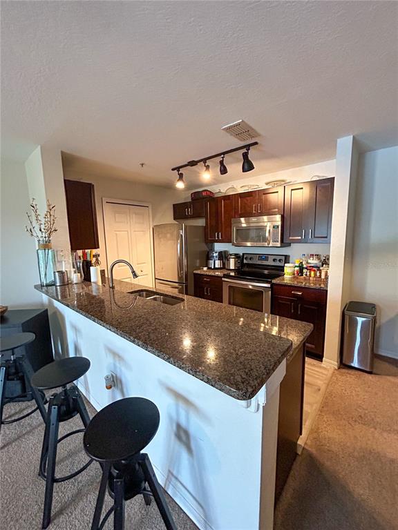 5447 Vineland Road, Unit 1209 Orlando, FL 32811 - Photo 5 of 27 a kitchen with stainless steel appliances granite countertop a sink a stove and a refrigerator