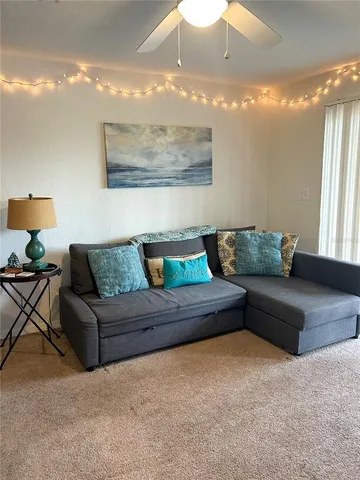 a living room with furniture and a chandelier