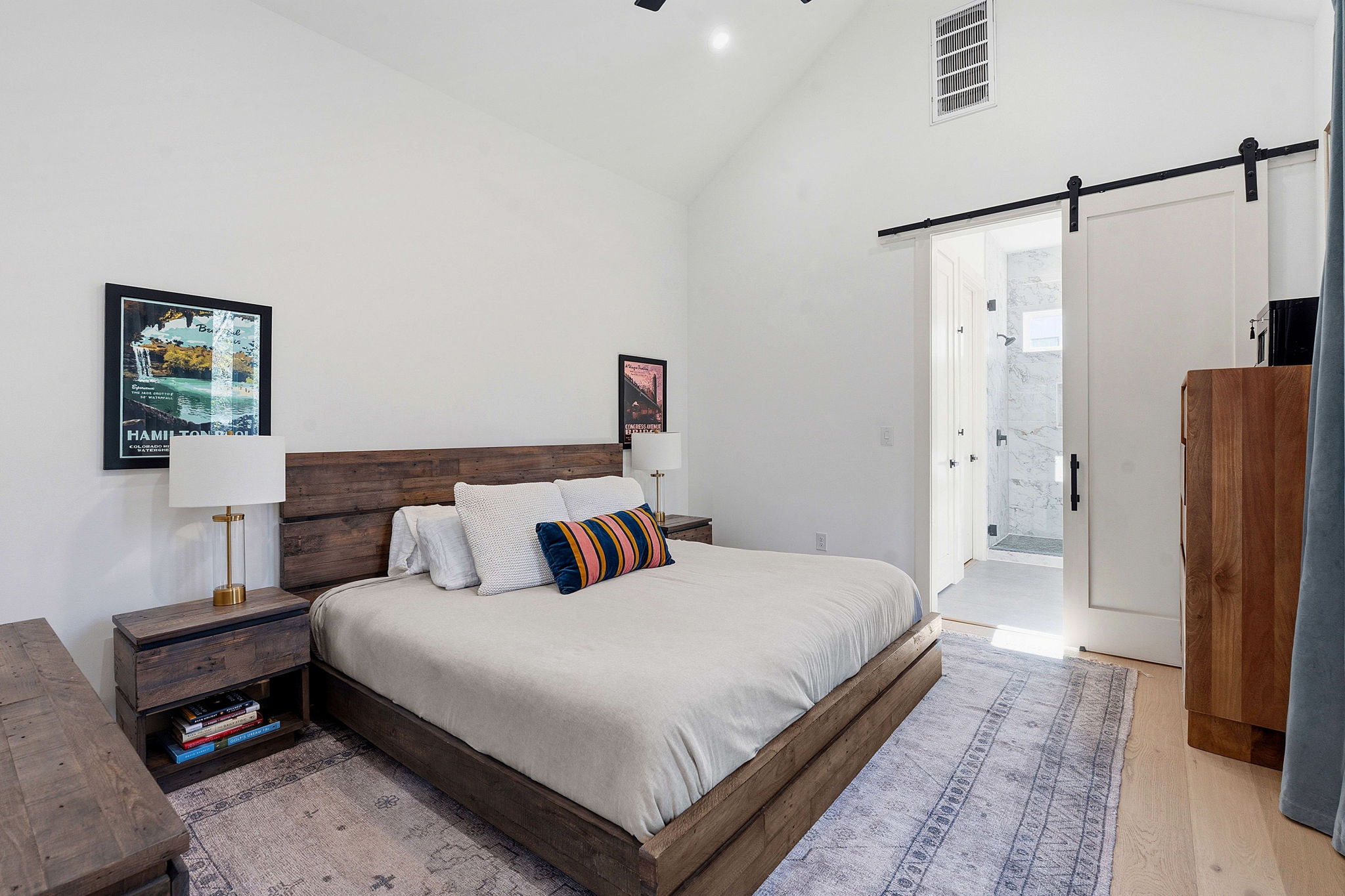 4313 Jinx Avenue, Unit 1 Austin, TX 78704 - Photo 21 of 40 Bedroom featuring a barn door, lofted ceiling, ceiling fan, connected bathroom, and light wood-style floors