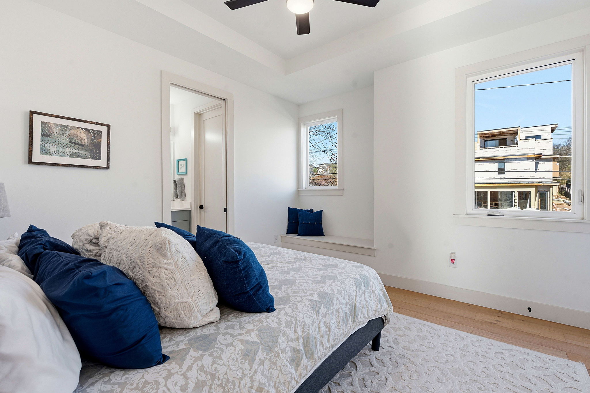 4313 Jinx Avenue, Unit 1 Austin, TX 78704 - Photo 23 of 40 Bedroom featuring wood finished floors, a tray ceiling, ceiling fan, and ensuite bath