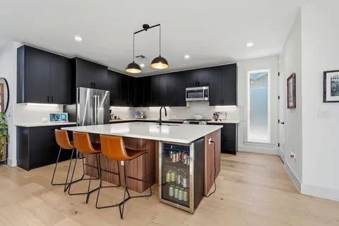 a kitchen with stainless steel appliances kitchen island a chandelier
