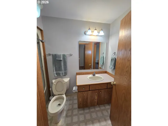 a bathroom with a toilet a sink and mirror