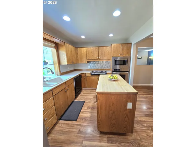 a kitchen with kitchen island wooden cabinets and sink