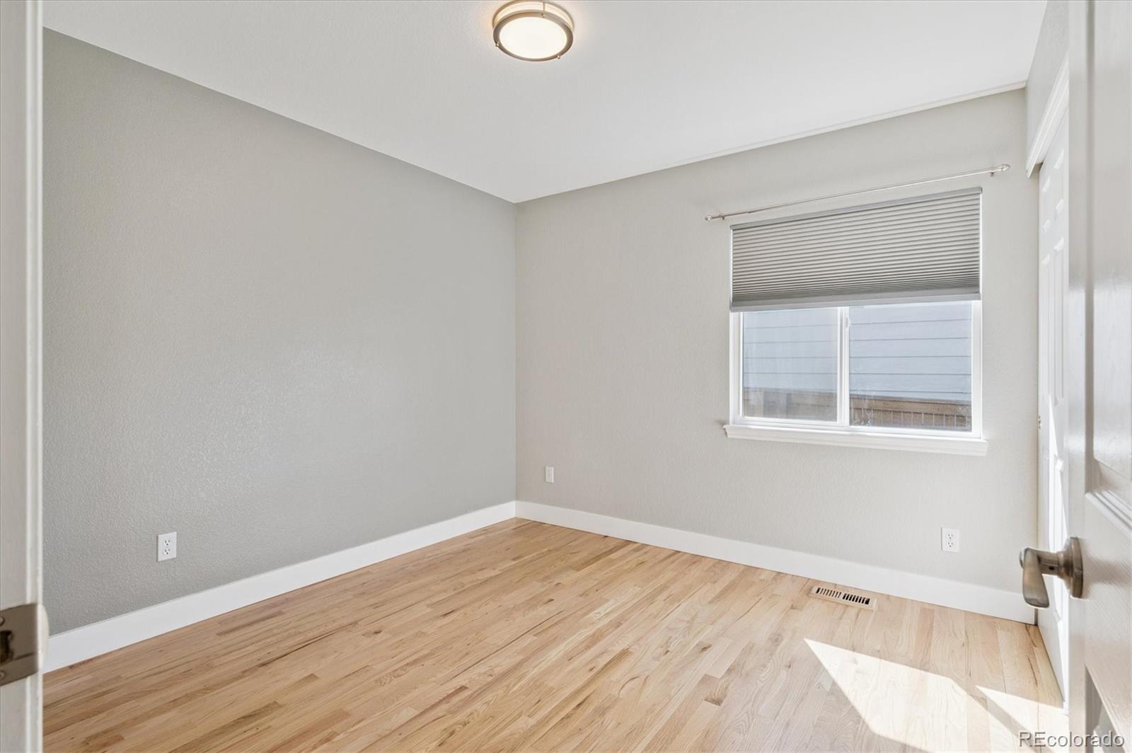 9793 Burberry Way Highlands Ranch, CO 80129 - Photo 20 of 29 a view of an empty room with wooden floor and a window