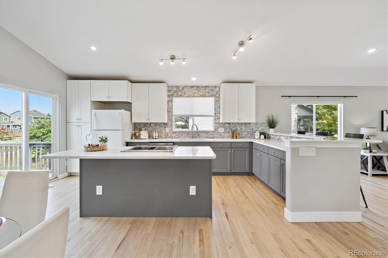 9793 Burberry Way Highlands Ranch, CO 80129 - Photo 10 of 29 a kitchen with a sink wooden floor and view living room