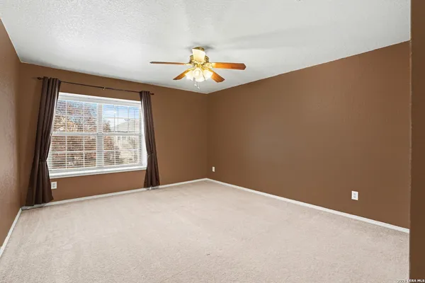 an empty room with closet and a ceiling fan
