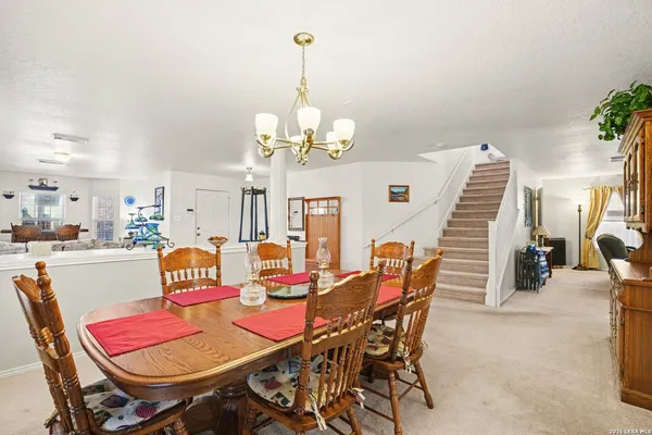 a dining room with furniture a chandelier and wooden floor