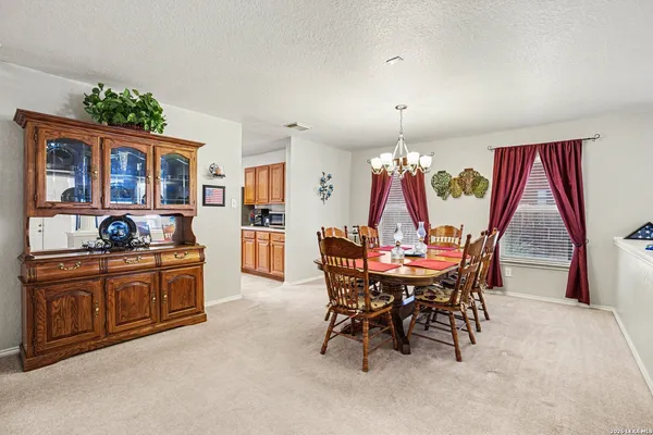 a view of a dining room with furniture and chandelier