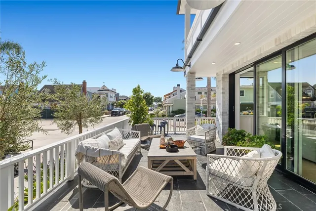 a view of a patio with couches chairs potted plants and floor to ceiling window