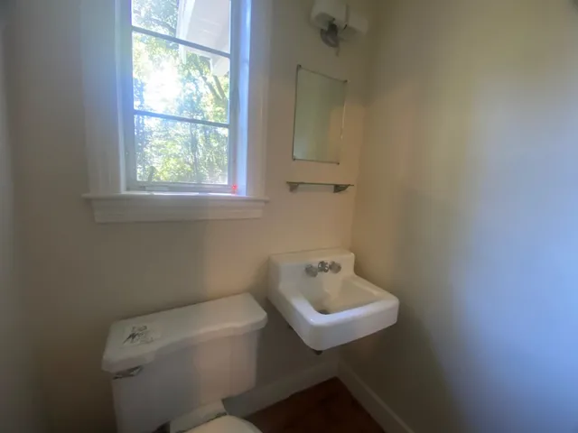 a bathroom with a sink a toilet and a window
