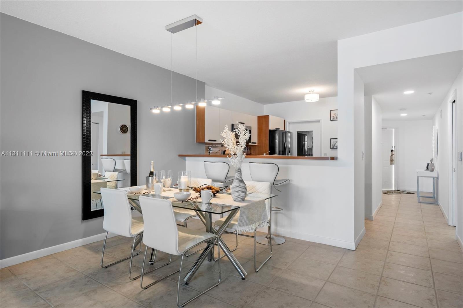 18100 North Bay Road, Unit 308 Sunny Isles Beach, FL 33160 - Photo 11 of 35 a dining room with furniture and a kitchen view
