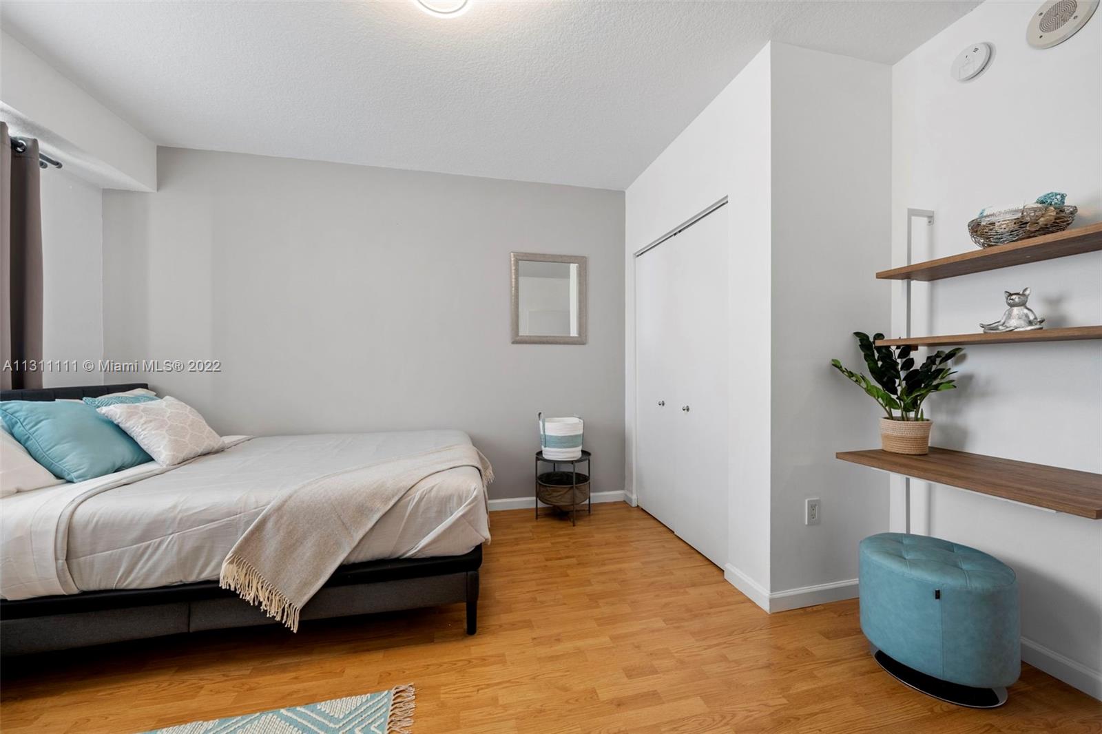 18100 North Bay Road, Unit 308 Sunny Isles Beach, FL 33160 - Photo 30 of 35 a bedroom with a bed and a potted plant on the dresser