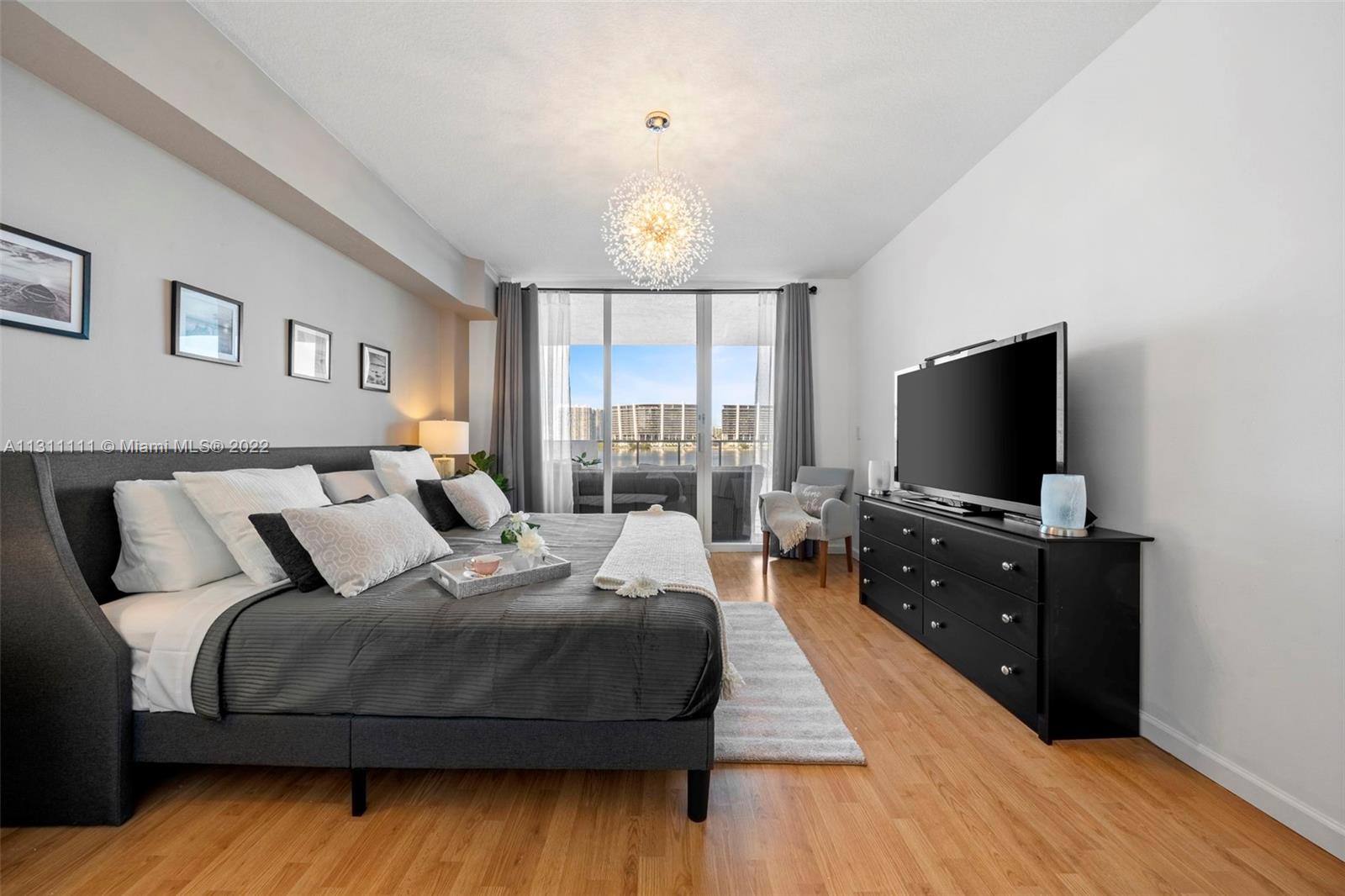 18100 North Bay Road, Unit 308 Sunny Isles Beach, FL 33160 - Photo 3 of 35 a bedroom with a bed and a flat screen tv