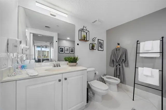 a bathroom with a double vanity sink toilet and mirror
