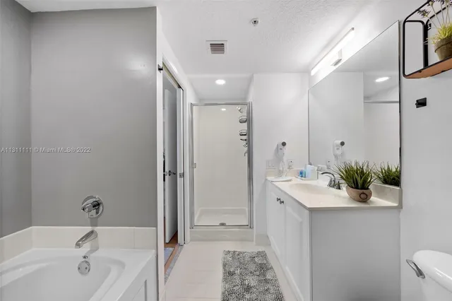 a bathroom with a tub sink and mirror