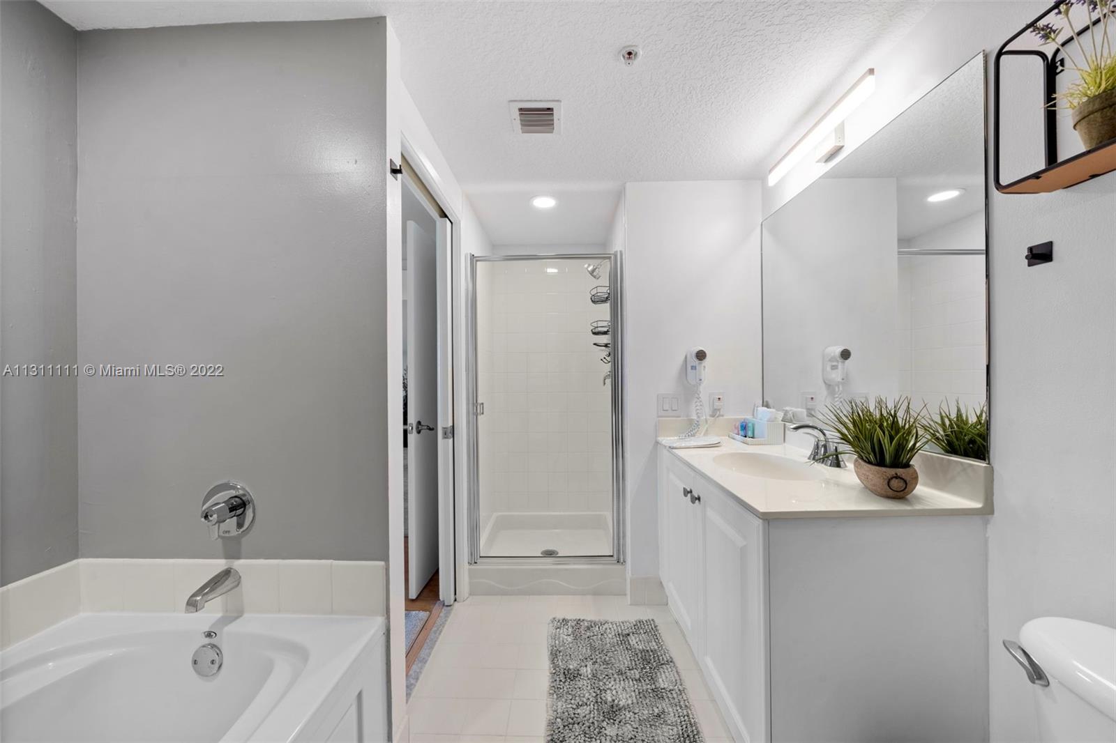 18100 North Bay Road, Unit 308 Sunny Isles Beach, FL 33160 - Photo 5 of 35 a bathroom with a tub sink and mirror