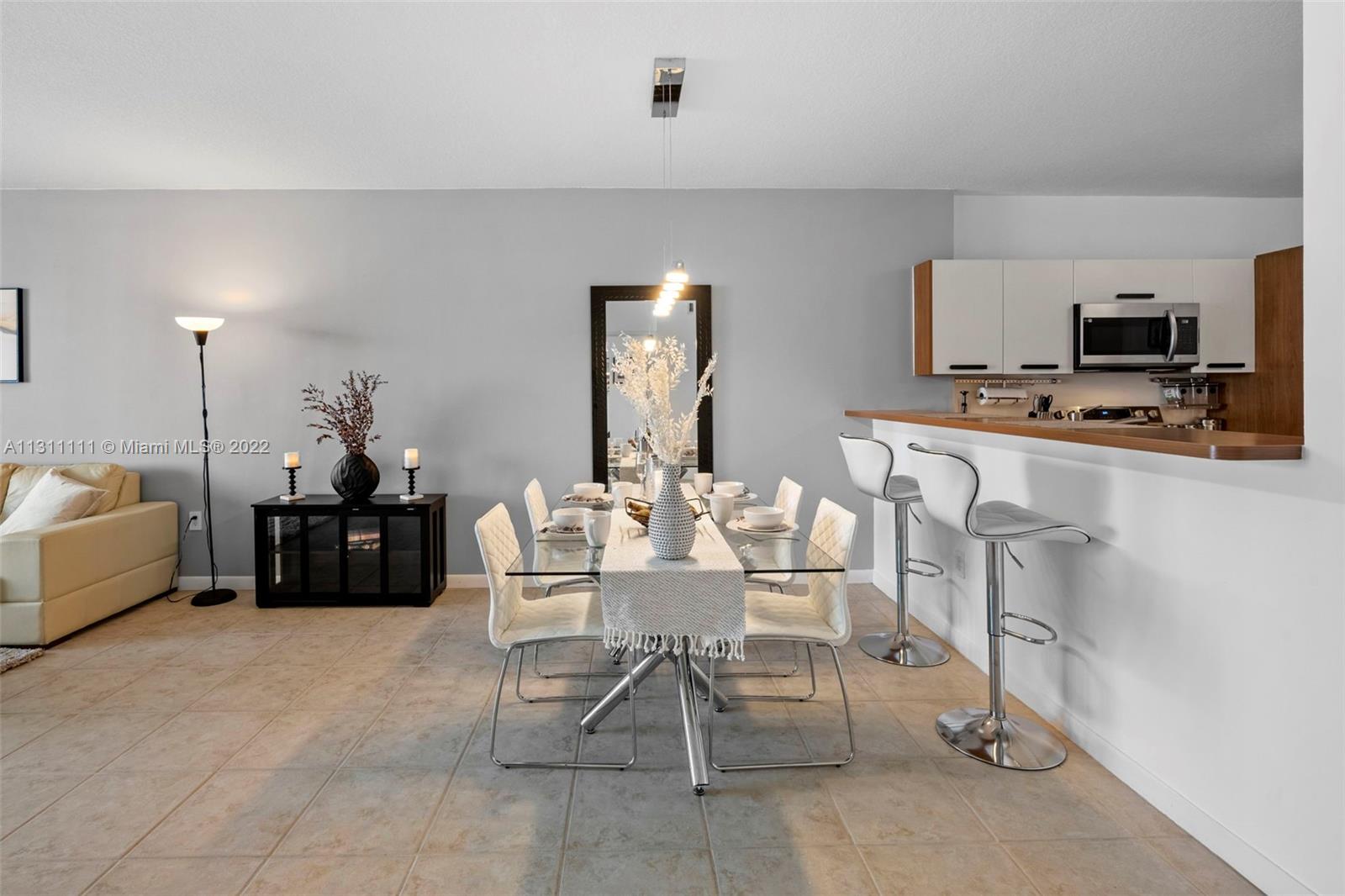 18100 North Bay Road, Unit 308 Sunny Isles Beach, FL 33160 - Photo 10 of 35 a living room with furniture a flat screen tv and a table