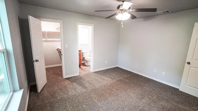 an empty room with closet and a chandelier fan