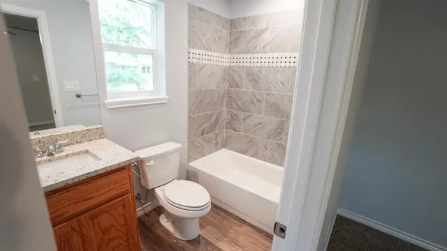 a bathroom with a granite countertop toilet a sink and a bathtub