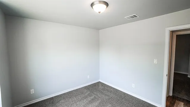 an empty room with windows and closet